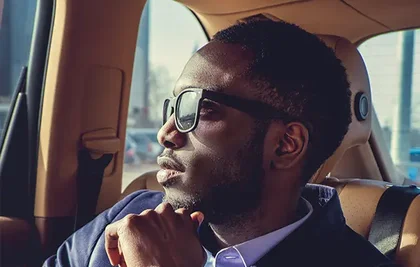 man inside a car looking outside with eyes closed