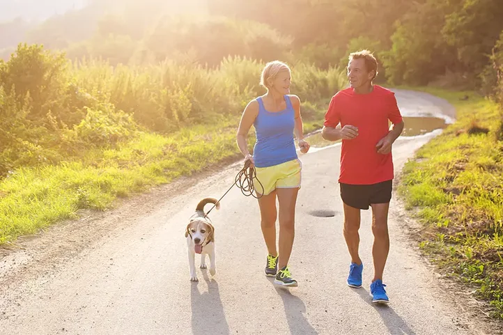 A man woman and dog jogging